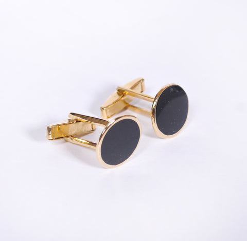 Gold cufflink with black dial.