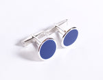 Silver cufflink with navy blue dial.
